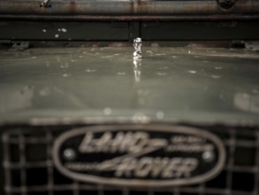 The front end of a 1950's Series One Land Rover, with a small hood ornament, parked at the Toronto