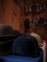 The tack room at the Toronto North York Hunt Club displaying a number of riding helmets, hats and a