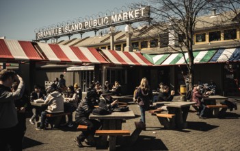 Crowds enjoy a lively day at an outdoor market under warm sunlight on Granville Island, in