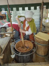 Disguised woman offering roasted almonds, Olde Hansa Restaurant, Old Town, Tallinn, Estonia