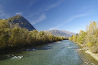 Wide river snakes through an autumnal valley, quiet sky with fine contrails, Lienz, Drau cycle