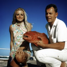 Couple posing with a trout grouper (Plectropomus pessuliferus), Red Sea, 1960s, Egypt