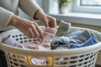 Woman's hands sorting socks in a laundry basket. Household chores and organization concept.