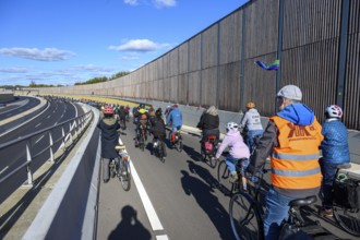 Cyclists on their way to the 16th construction phase of the A100. Person wearing sweater with