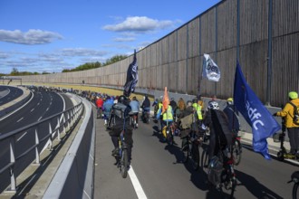 Cyclists on their way to the 16th construction phase of the A100. Flags from adfc and Respect