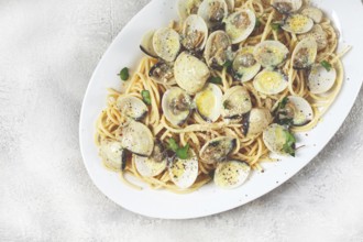 Spaghetti with vongole clams, in cream sauce, carbonara, on a white plate, homemade, top view, no