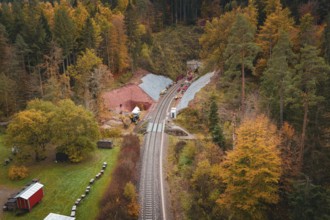 Railway line with tunnel construction, surrounded by autumnal forests and landscape panorama,