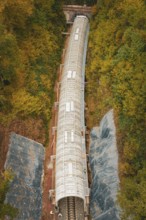 Aerial view of a long tunnel on a railway line surrounded by autumn leaves, Hermann-Hesse-Bahn