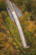 Aerial view of a railway tunnel in a landscape surrounded by autumn trees, Hermann-Hesse-Bahn