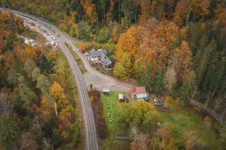 Railway line and buildings in autumn forest, village atmosphere, Hermann-Hesse-Bahn construction