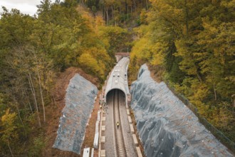 Tunnel construction along the railway line with construction workers surrounded by autumn leaves,
