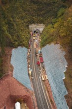 Rail construction in the forest with tunnel opening, surrounded by autumn leaves,