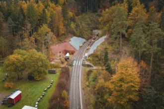 Route of railway tracks in autumn forest landscape with tunnel construction project,