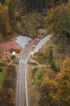 A railway line with construction and tunnel work, surrounded by autumn forests, Hermann-Hesse-Bahn