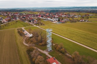 Rural landscape with an observation tower and a village in the distance, crossed by fields and