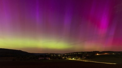 Night sky over a village with aurora borealis. Neckargemünd area, Rhein-Neckar District,
