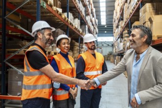 Diverse logistics team and supervisor standing in a distribution warehouse, a manager