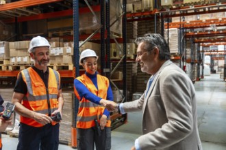 Manager shaking hands with a woman warehouse worker while male team members smile, symbolizing