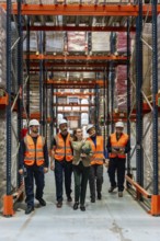 Female warehouse manager and diverse team of logistics workers are collaborating and inspecting
