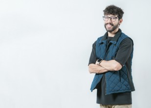 Smiling and handsome guy with glasses holding arms crossed isolated. Portrait of cool and handsome