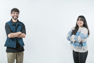 Cheerful young multiethnic couple with arms crossed, isolated. Smiling young couple with crossed