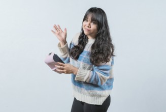 Worried girl with no money holding empty wallet, isolated. Young woman shaking her empty wallet