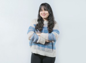 Young Asian female with crossed arms on white background. Portrait of beautiful and smiling Asian
