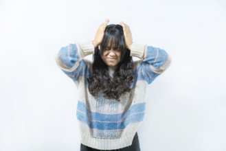 Unhappy woman with headache isolated. Painful girl with migraine holding his head isolated