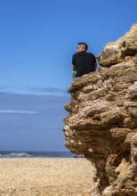 Tourists watch the waves of the Atlantic on the rocky plateau of Sito, also known as Forte São