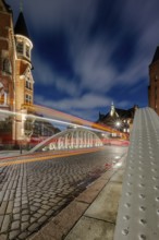 Blue hour and traces of light in the Speicherstadt Hamburg on the Neuerwegsbrücke with cobblestones