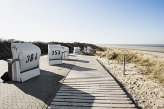 Beach chairs in the dunes and blue sky in winter, Spiekeroog, East Frisian Islands, Lower Saxony,
