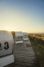 Beach chairs in the dunes and blue sky in winter, sunset, Spiekeroog, East Frisian Islands, Lower