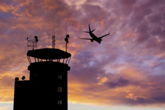 Air traffic control tower at airport as airplane takes off