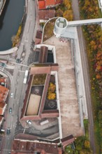 Aerial view of a building complex at an intersection with bridge and railroad tracks in autumn, ZOB
