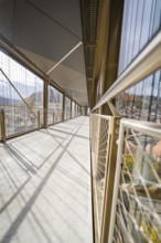 Modern bridge with long shadows and a network of metallic mesh along the sides, ZOB Calw, Hermann