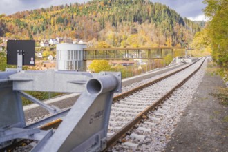 Tracks along a modern building with a bridge against an autumn mountain backdrop, ZOB Calw, Hermann