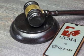 Smartphone with GEMA and OpenAI logo next to a judge's hammer