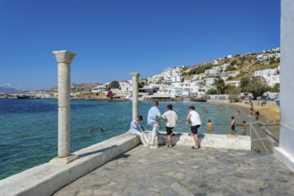 Mykonos, Cyclades, Greece - Young people on the small town beach Paralia Cheras Mikonou right at
