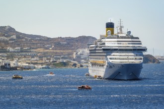 Mykonos, Cyclades, Greece - Cruise ship COSTA FORTUNA is located in the bay against the backdrop of