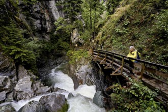 Female hiker on wooden walkway on the Diosaz mountain river in the gorge, Gorges de la Diosaz, Les