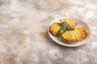 Fried crispy Chicken pancakes on brown concrete background. side view, copy space