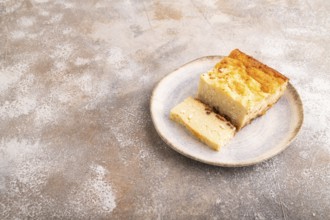 ?ottage cheese ?asserole, Curd cake, with dried apricots and raisins on brown concrete background,