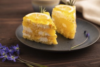 Lemon cake on brown wooden background and linen textile, cup of coffee, side view, close up,