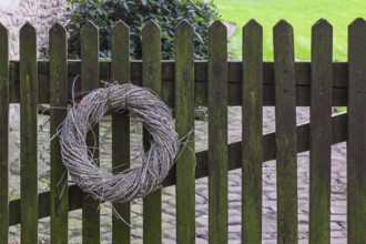 Wreath made of natural materials on an old wooden fence, Münsterland, North Rhine-Westphalia,