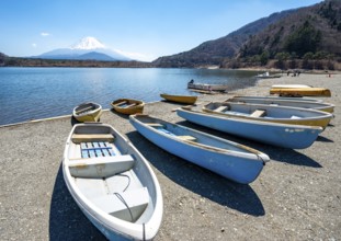 Rowing boats on shore, view across the lake to Mt Fuji volcano, Motosu Lake, Yamanashi Prefecture,