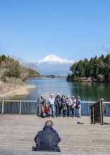 Japanese tour group takes souvenir photo, Fuji-mae observation deck, Mount Fuji volcano and Lake