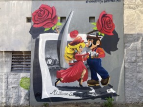 Street art mural in Buenos Aires with a comic couple dancing tango and the inscription mi buenos
