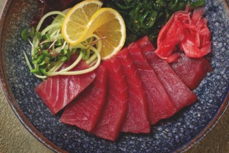 Tuna sashimi with daikon and wakame salad, pickled ginger, in a bowl