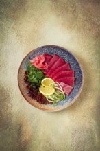 Tuna sashimi with daikon and wakame salad, pickled ginger, in a bowl