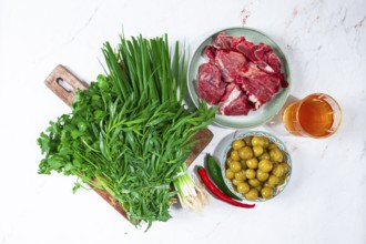 Ingredients for cooking chakapuli, canned tkemali, meat, herbs Georgian cuisine, top view